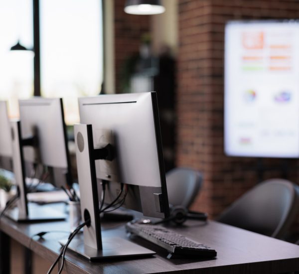 Nobody in office with multiple monitors at customer service desk, call center helpline support to give telecommunication assistance. Empty helpdesk with client telephony reception.